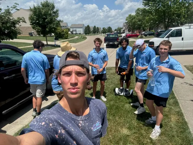 The Infiniti Home Services crew on a lawn beside the van