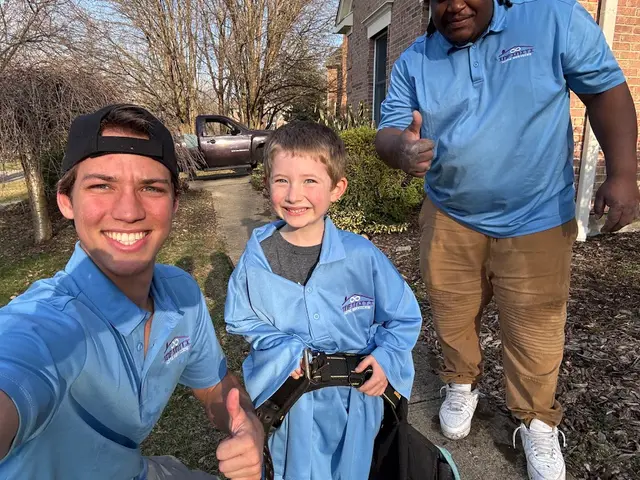 Two crew members giving a thumbs up with a young customer in a matching shirt