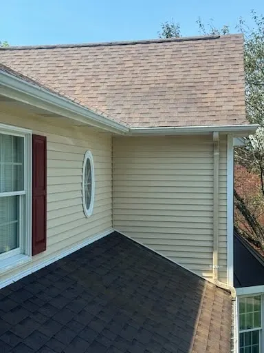 Light siding and a round window after a house wash