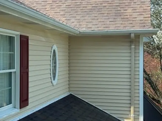 Light siding and a round window after a house wash